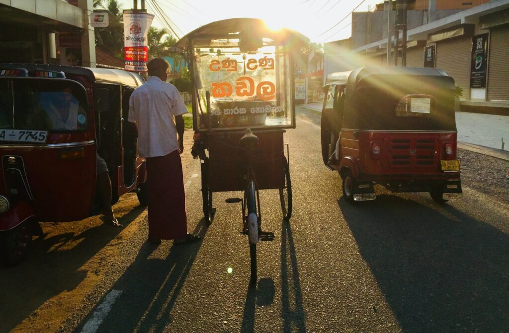 Street vendor preparing Kottu Roti on a hot griddle with metal blades in Colombo at night — supporting travel image 3